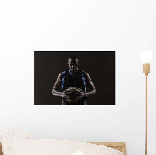 Portrait of basketball player holding a ball Wall Mural
