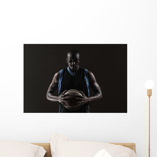 Portrait of basketball player holding a ball Wall Mural