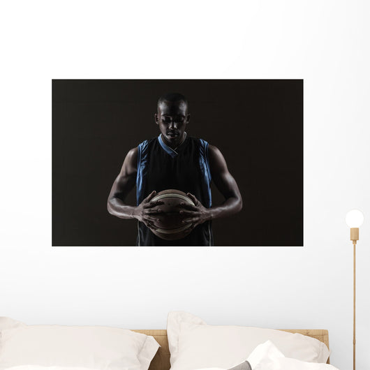 Portrait of basketball player holding a ball Wall Mural
