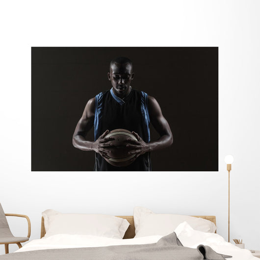 Portrait of basketball player holding a ball Wall Mural