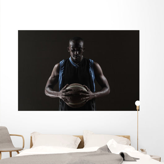 Portrait of basketball player holding a ball Wall Mural