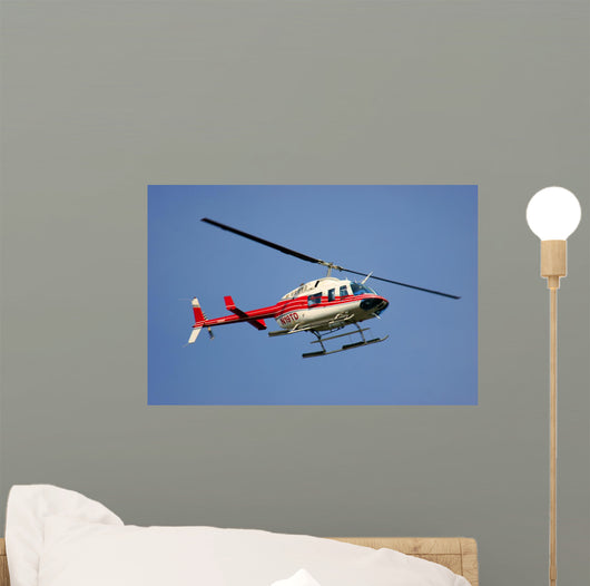 helicopter flying against a deep blue sky Wall Mural