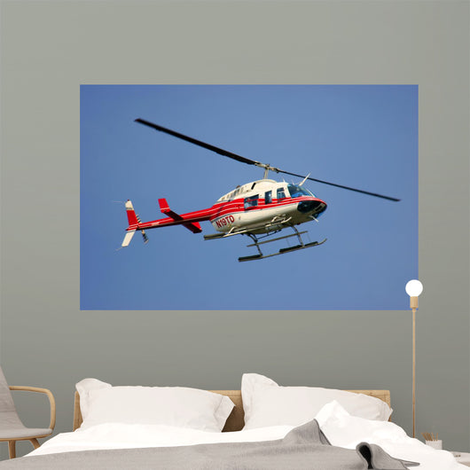 helicopter flying against a deep blue sky Wall Mural
