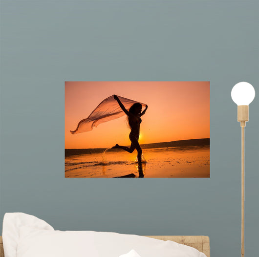 Silhouette of girl running on the beach Wall Mural