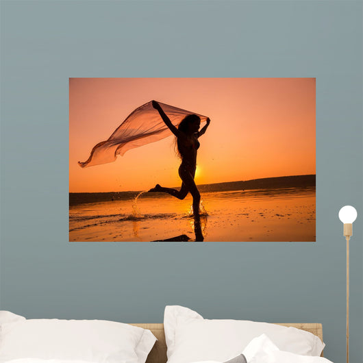 Silhouette of girl running on the beach Wall Mural