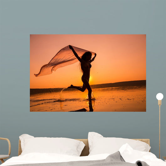 Silhouette of girl running on the beach Wall Mural
