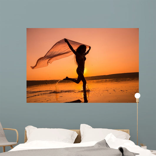 Silhouette of girl running on the beach Wall Mural