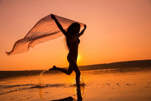 Silhouette of girl running on the beach Wall Mural