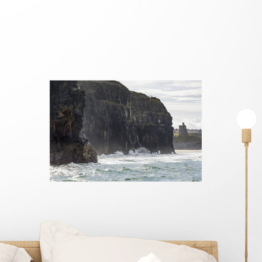 Dark straight cliffs with ruined castle turret Wall Mural