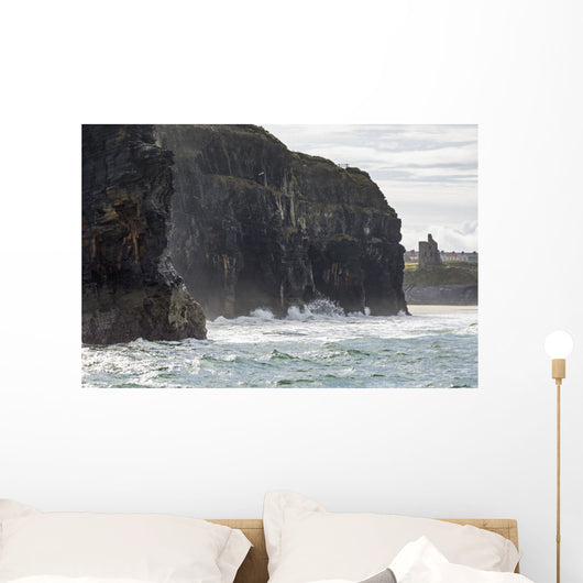 Dark straight cliffs with ruined castle turret Wall Mural