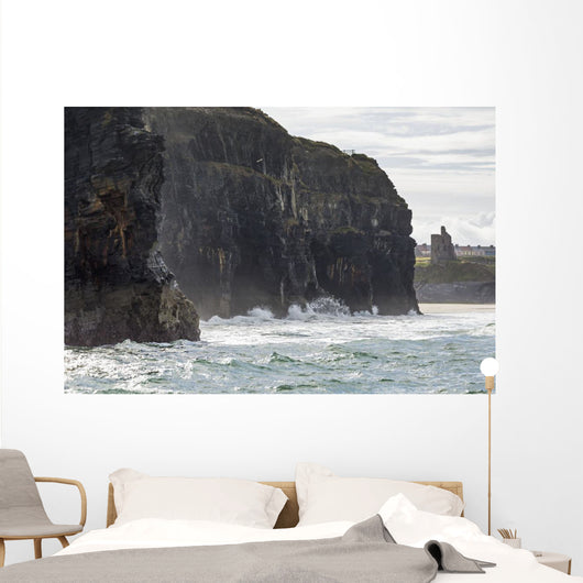 Dark straight cliffs with ruined castle turret Wall Mural