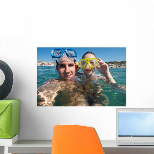 Lovely couple enjoying snorkeling during their vacation Wall Mural