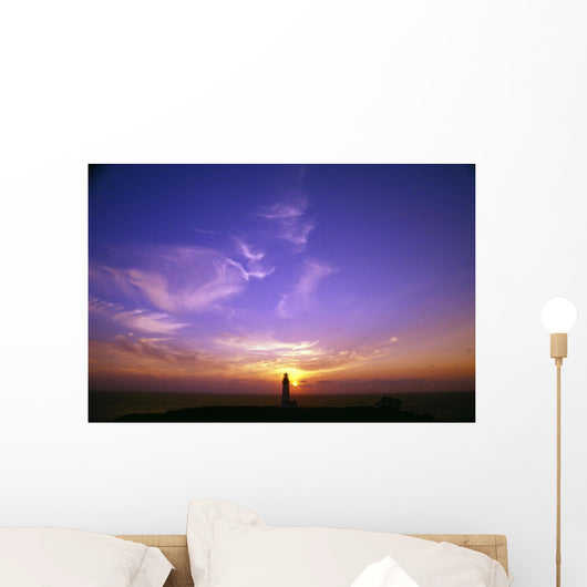 Luminous Sky Behind Distant Lighthouse Wall Mural