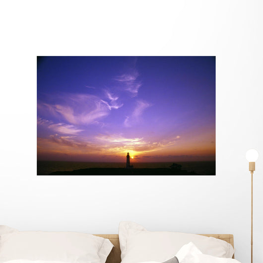 Luminous Sky Behind Distant Lighthouse Wall Mural