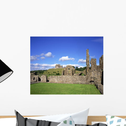 Old Ruins Of An Abbey With A Castle In The Background Wall Mural
