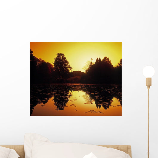 Silhouetted Home And Trees Near Water Wall Mural