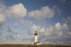 Lighthouse With Cloudy Backdrop Wall Mural
