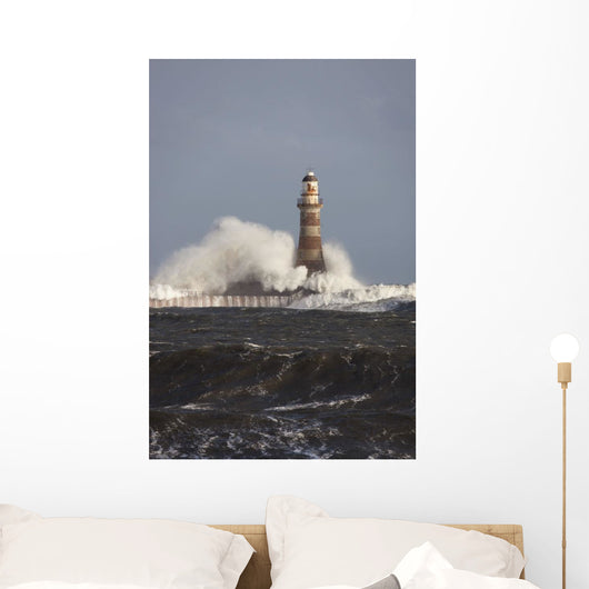 Waves Crashing Against A Lighthouse Wall Mural