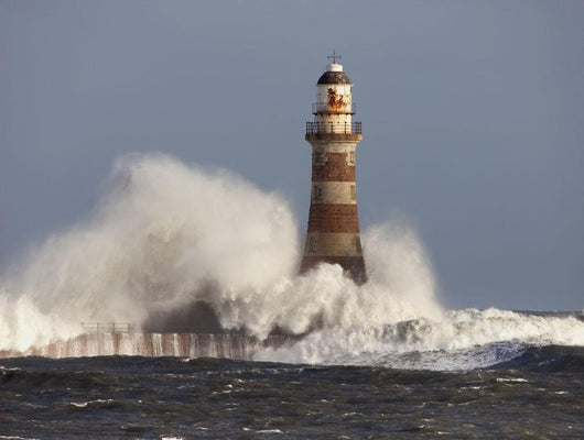 Waves Crashing Against A Lighthouse Wall Mural