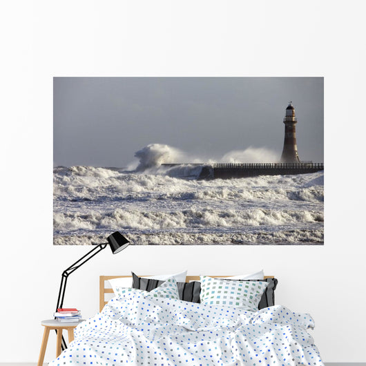 Waves Crashing Against A Pier With A Lighthouse Wall Mural