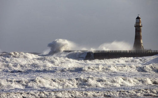 Waves Crashing Against A Pier With A Lighthouse Wall Mural