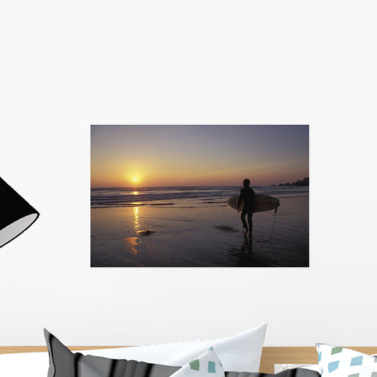 Silhouetted Surfer On Sandy Beach At Sunset Wall Mural