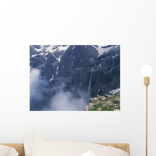 Walker Looking Over Waterfall At Cirque De Gavarnie Wall Mural