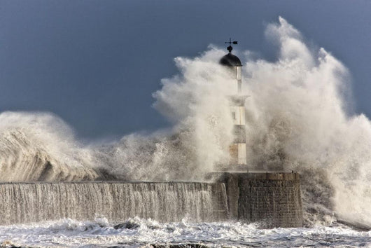 Waves Crashing Up Against A Lighthouse Wall Mural