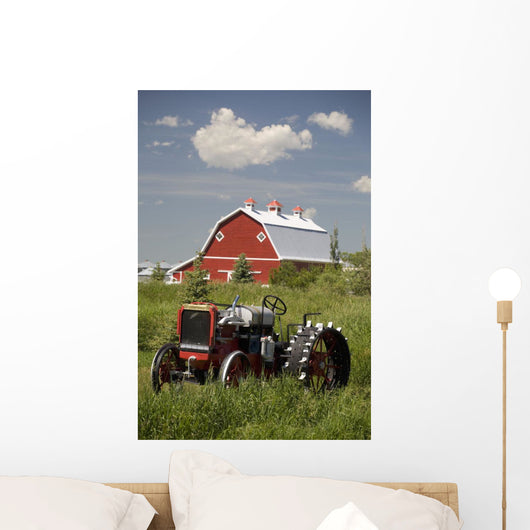 Old Red Tractor In A Field With A Red Barn In The Background Wall Mural