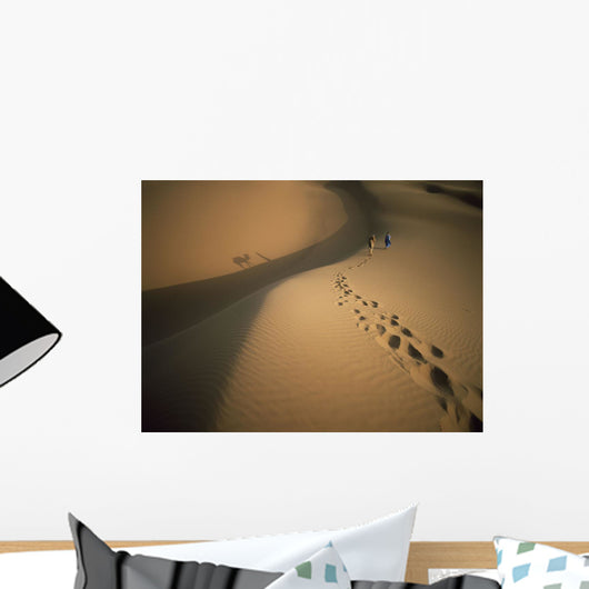 Man's Lonely Travel through the Desert with Trusted Camel Companion Wall Mural