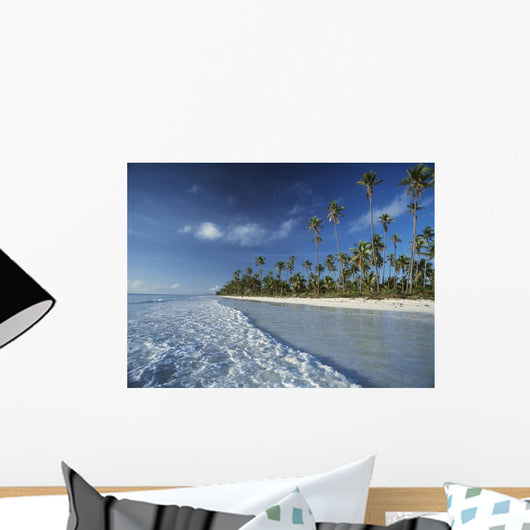 Waves Lapping Shore Of Beach With Palm Trees Behind Wall Mural