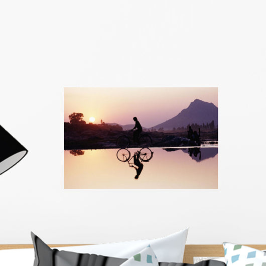 Bicyclist Crossing Shallow River At Sunset With Women Wall Mural