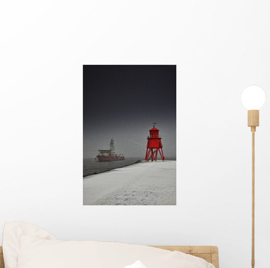A Red Lighthouse Along The Coast In Winter With A Boat Off The Shore Wall Mural