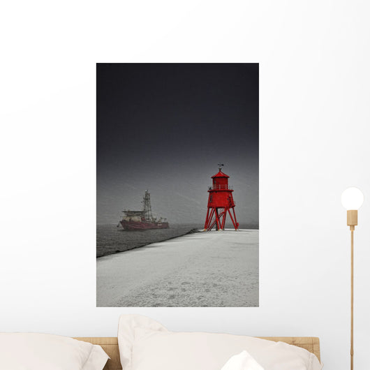 A Red Lighthouse Along The Coast In Winter With A Boat Off The Shore Wall Mural