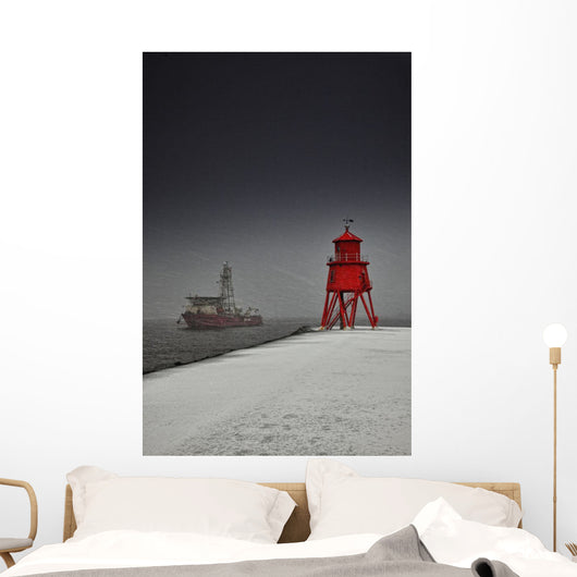 A Red Lighthouse Along The Coast In Winter With A Boat Off The Shore Wall Mural