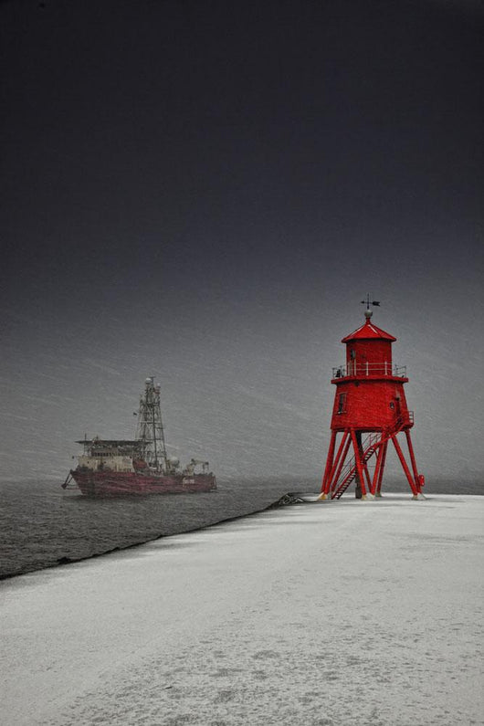 A Red Lighthouse Along The Coast In Winter With A Boat Off The Shore Wall Mural