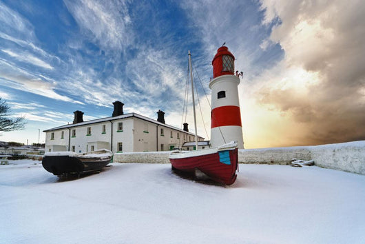 Boats Sitting On A Frozen Surface With A Lighthouse And Building Wall Mural