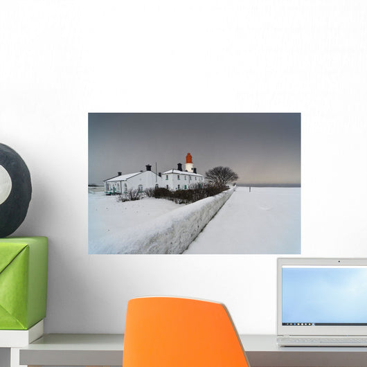 A Snow Covered Fence With A Lighthouse And Building In The Background Wall Mural
