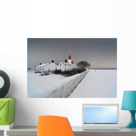 A Snow Covered Fence With A Lighthouse And Building In The Background Wall Mural