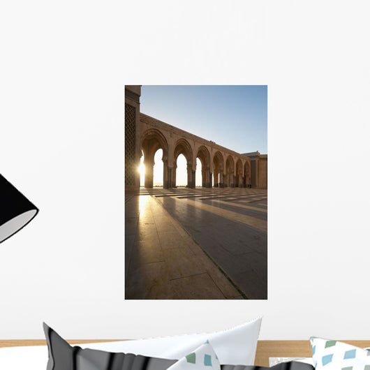 A row of archways against a blue sky and sunlight shining through Wall Mural