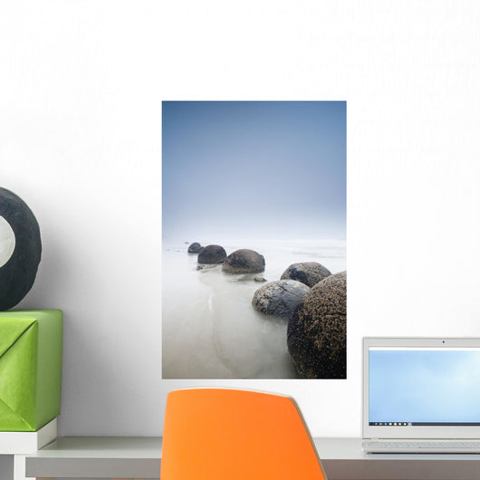 Boulders In A Row In The Shallow Water At The Beach Along The Coast Wall Mural