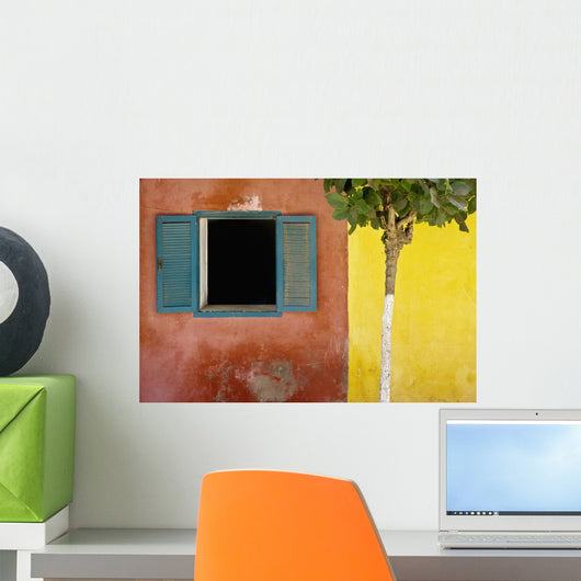 A Tree Outside A Colorful Building And A Window With Blue Shutters Wall Mural