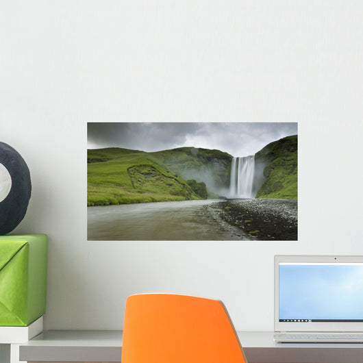 A Waterfall Over A Grassy Cliff Wall Mural