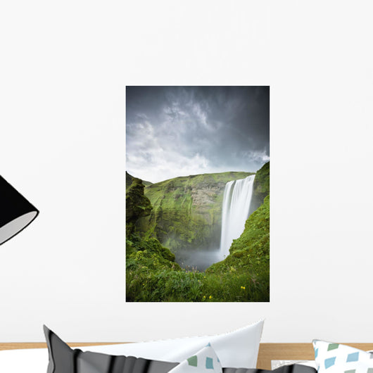 A Waterfall Over A Grassy Cliff Wall Mural