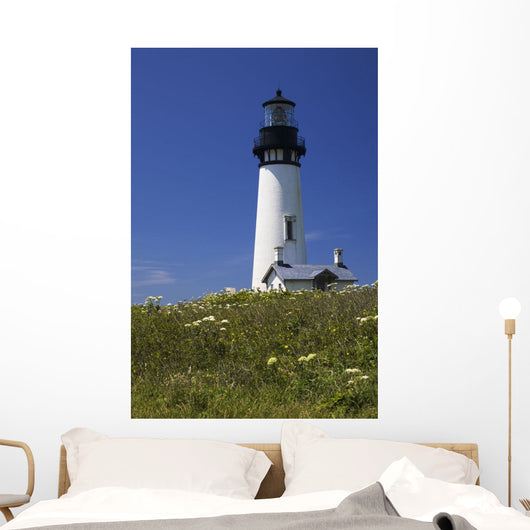 White Lighthouse With A Blue Sky And Wildflowers Wall Mural