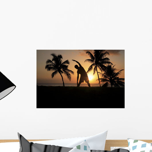 Silhouette Of Man Stretching Near The Beach As The Golden Sunsets Wall Mural