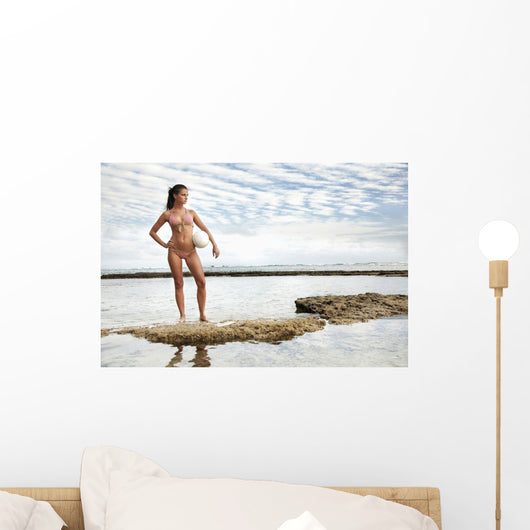 Beautiful Young Female At The Beach Posing With A Volleyball Wall Mural