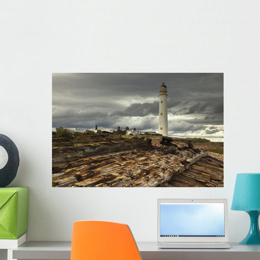 A Lighthouse And Piles Of Logs On The Shore Wall Mural