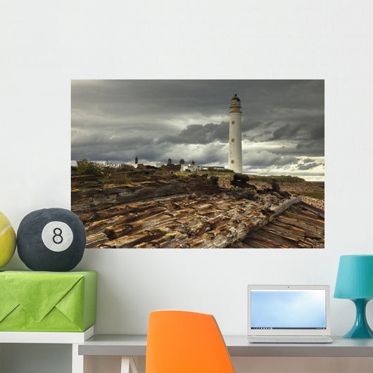 A Lighthouse And Piles Of Logs On The Shore Wall Mural