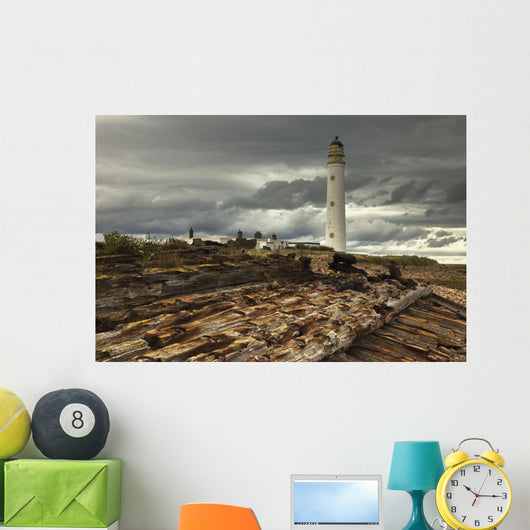 A Lighthouse And Piles Of Logs On The Shore Wall Mural